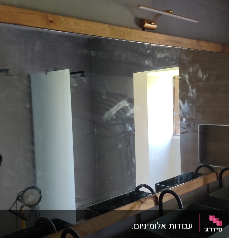 מראה גדולה עם מסגרת עץ ותאורה עליונה